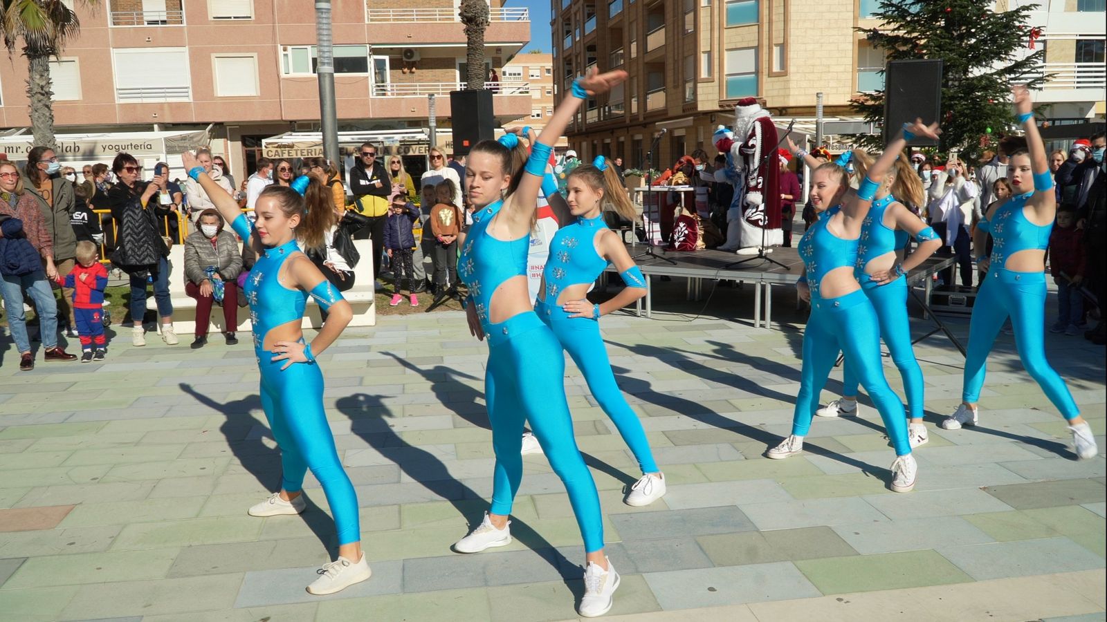 Bailarinas vestidas de azul actúan en la plaza