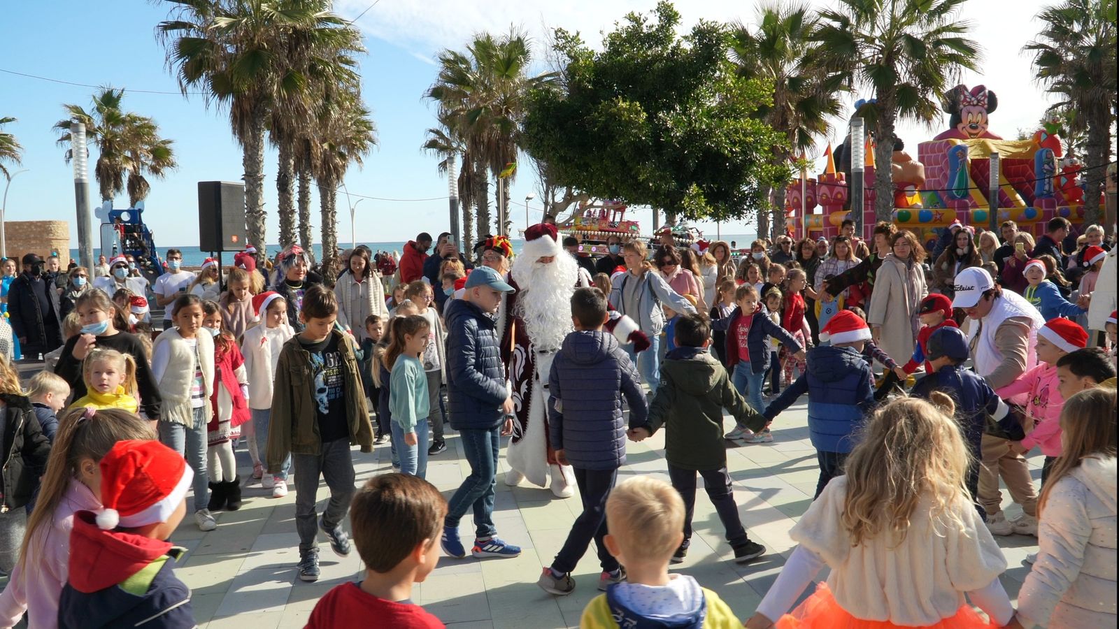 Niños y familias bailan en corro en la plaza durante la fiesta